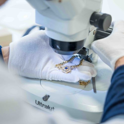 Une main gantée tenant un collier